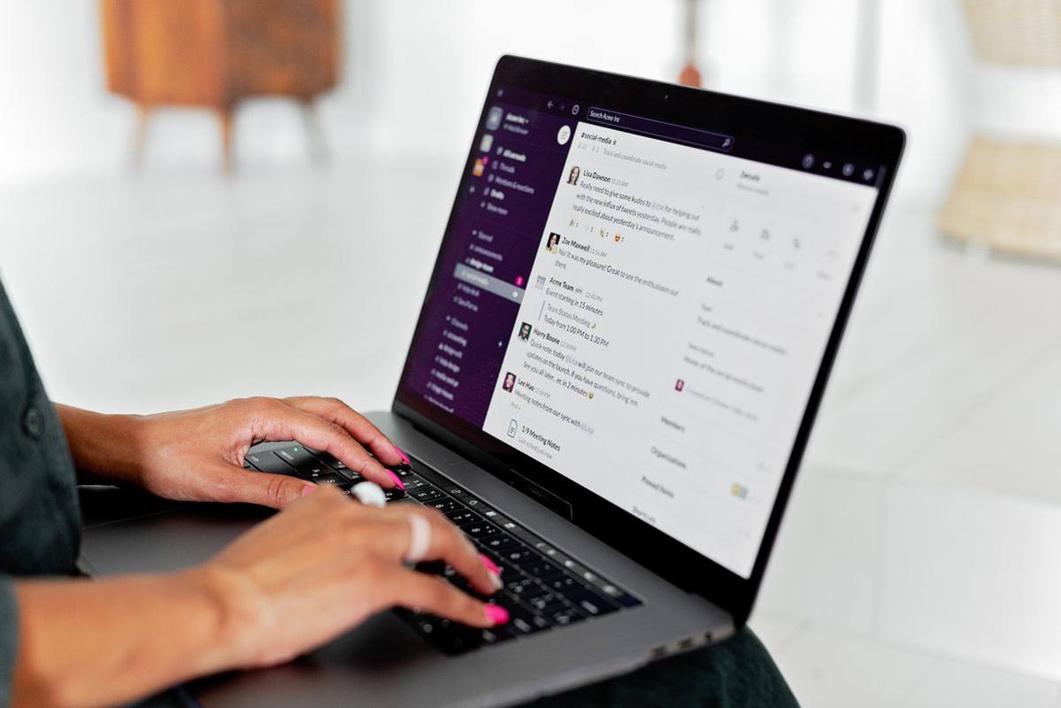 Professional typing on a laptop with a communication inbox open.
