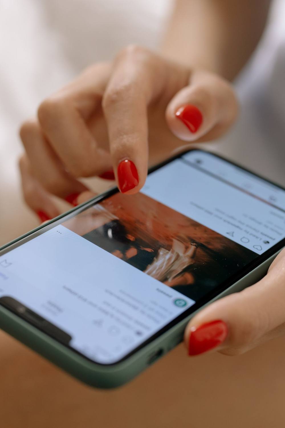 Close-up of a person scrolling a social media feed on a phone.